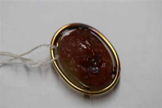 An early 20th century gold mounted oval agate clip brooch, gross 14.8 grams.